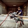 Metabo Kappsäge KGS 305 M mit Zugfunktion im Einsatz auf Untergestell mit Radsatz.
