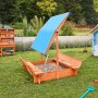 Home Deluxe Sandkasten Buddelkiste mit blauem Dach und Sitzbänken im Garten.
