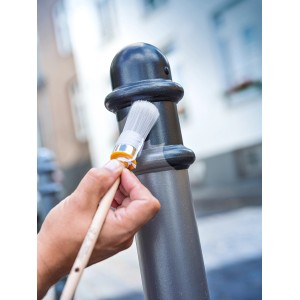Lackierarbeiten mit LUX Ringpinsel Gr. 4 (Ø 25 mm) an einem Metallpfosten im Außenbereich.