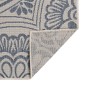 Blauer Outdoor-Teppich mit floralem Flachgewebe-Muster. Eine Ecke ist umgeschlagen und zeigt die strukturierte Unterseite.