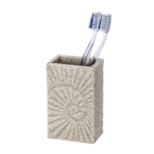 Beiger Zahnputzbecher Fossil mit Reliefmuster und zwei Zahnbürsten.