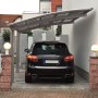 Ximax Carport Portoforte-80 im Edelstahl-Look mit Auto. Moderner Metallcarport mit gebogenem Dach.