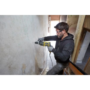 Mann bohrt mit Stanley FatMax Schlagbohrmaschine FMEH850K in Wand, inkl. Koffer.