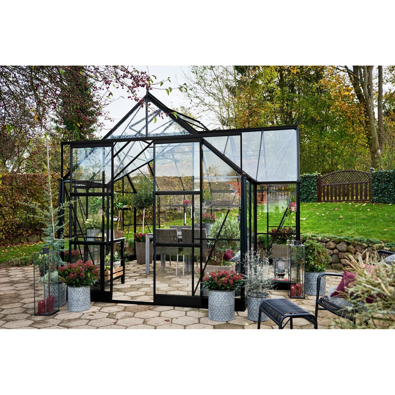 Halls Gewächshaus Garden Room, 12,9 m², schwarz, mit Glas und Aluminiumrahmen im Garten.