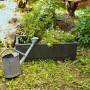 Rechteckiger, anthrazitfarbener KHW Pflanzkasten mit Blumen und Gießkanne im Garten.