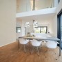 Helle Vliestapete Betonoptik in modernem Esszimmer mit Tisch und Stühlen.
