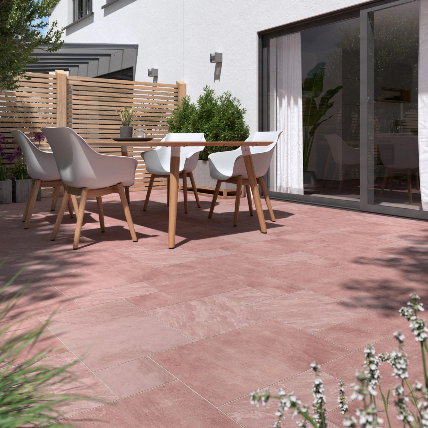 Verlegte Sandsteinplatten Modak im Römischen Verband auf einer Terrasse mit Gartenmöbeln.