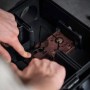Rattenfalle spannen: Hände spannen Schlagfalle in Köderbox für Rattenbekämpfung.