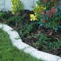 Weiße Mähkante Maxi aus Beton, wassergestrahlt, als Rasenkante im Garten.