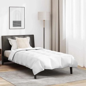Weiße Winterbettdecke mit Kissen auf modernem Bett. Gesteppte Daunenfeder-Decke mit schwarzem Rand für gemütliches Schlafzimmer.