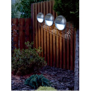 Anthrazitfarbene Solar-Zaunleuchten am Holzzaun im Garten. Dekorative LED-Beleuchtung für den Außenbereich.