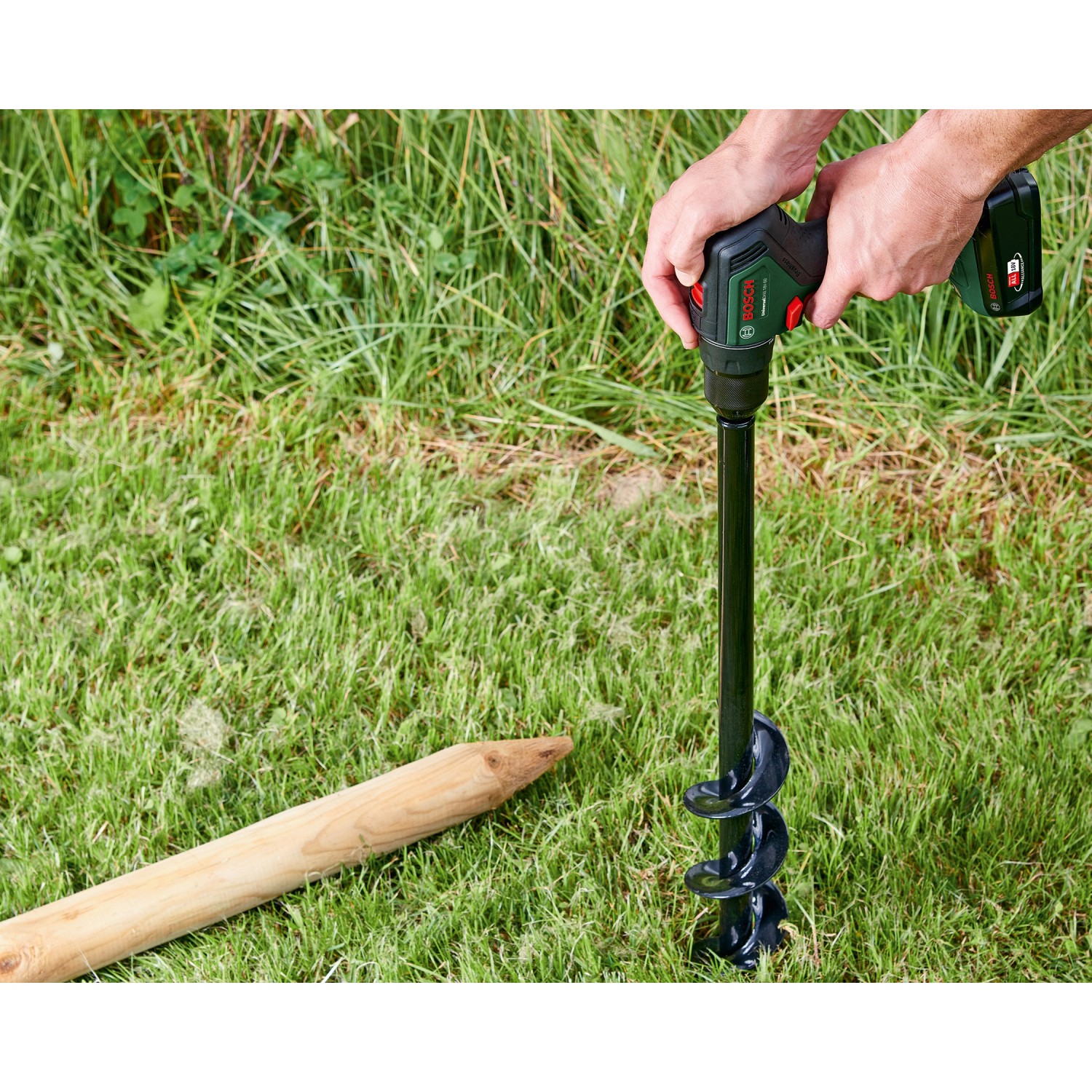 Bosch Akku-Schlagbohrschrauber UniversalImpact 18V-60 im Einsatz mit Erdlochbohrer im Garten.