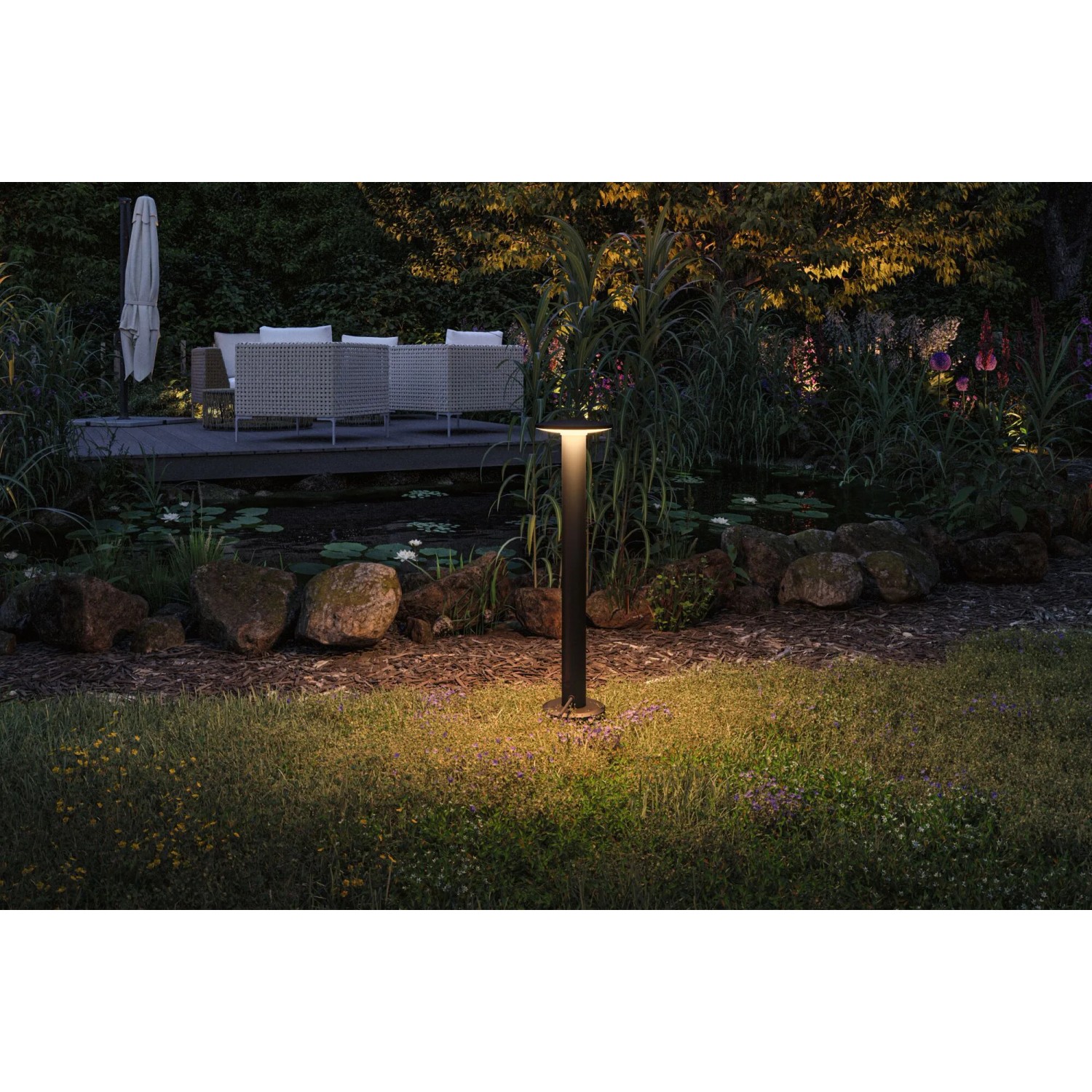 Paulmann LED-Pollerleuchte Plate Plug & Shine, anthrazit, im Garten mit warmem Licht.