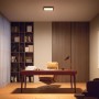 Philips Hue Aurelle LED-Panel, 30x30 cm, in Schwarz, montiert an einer Decke in einem Arbeitszimmer.