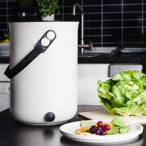 Skaza Küchenkompostbehälter Bokashi Organko Starterset in Cremeweiß mit Tragegurt und Küchenabfällen.