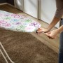Leifheit Bügeltisch Fashion M Plus mit Blumenmuster und Person, die den Bezug befestigt.