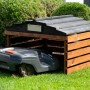 Dobar Mährobotergarage aus Holz, braun-schwarz, mit Mähroboter im Garten.
