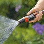 Gardena Reinigungsspritze in Aktion: Hand hält Spritze, Wasserstrahl ist sichtbar.