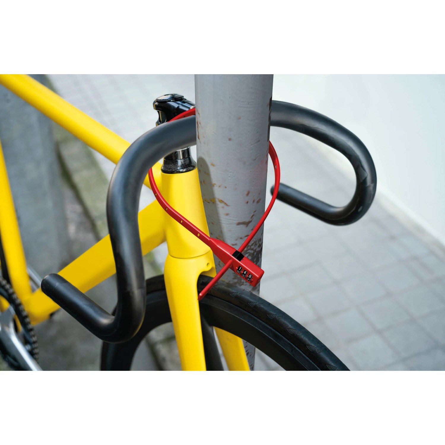 Rotes Basi Kabelbinderschloss am Fahrrad befestigt, sichert vor Diebstahl.