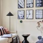 Frau benutzt Bosch Atino Linienlaser mit Maßband zum Ausrichten von Bildern an einer Wand.