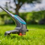 Gardena Akku-Trimmer PowerTrim 30/18V im Einsatz auf Rasenfläche.