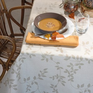 Beige Venilia Tischdecke Véniline Leaf (Meterware) mit Blätter-Muster auf gedecktem Tisch.