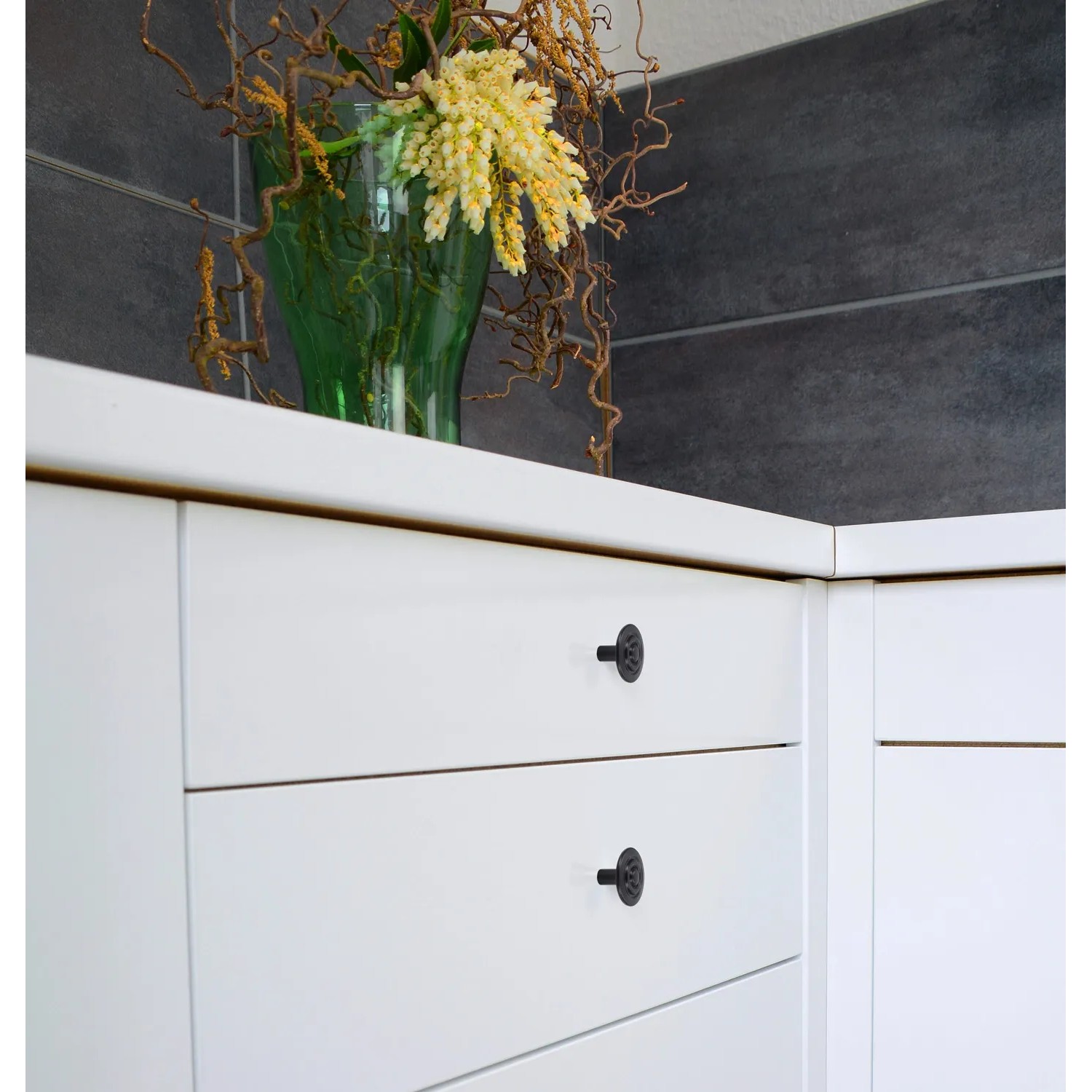 Schwarzer Siro Möbelknopf Landhaus an weißen Schubladen im Bad.