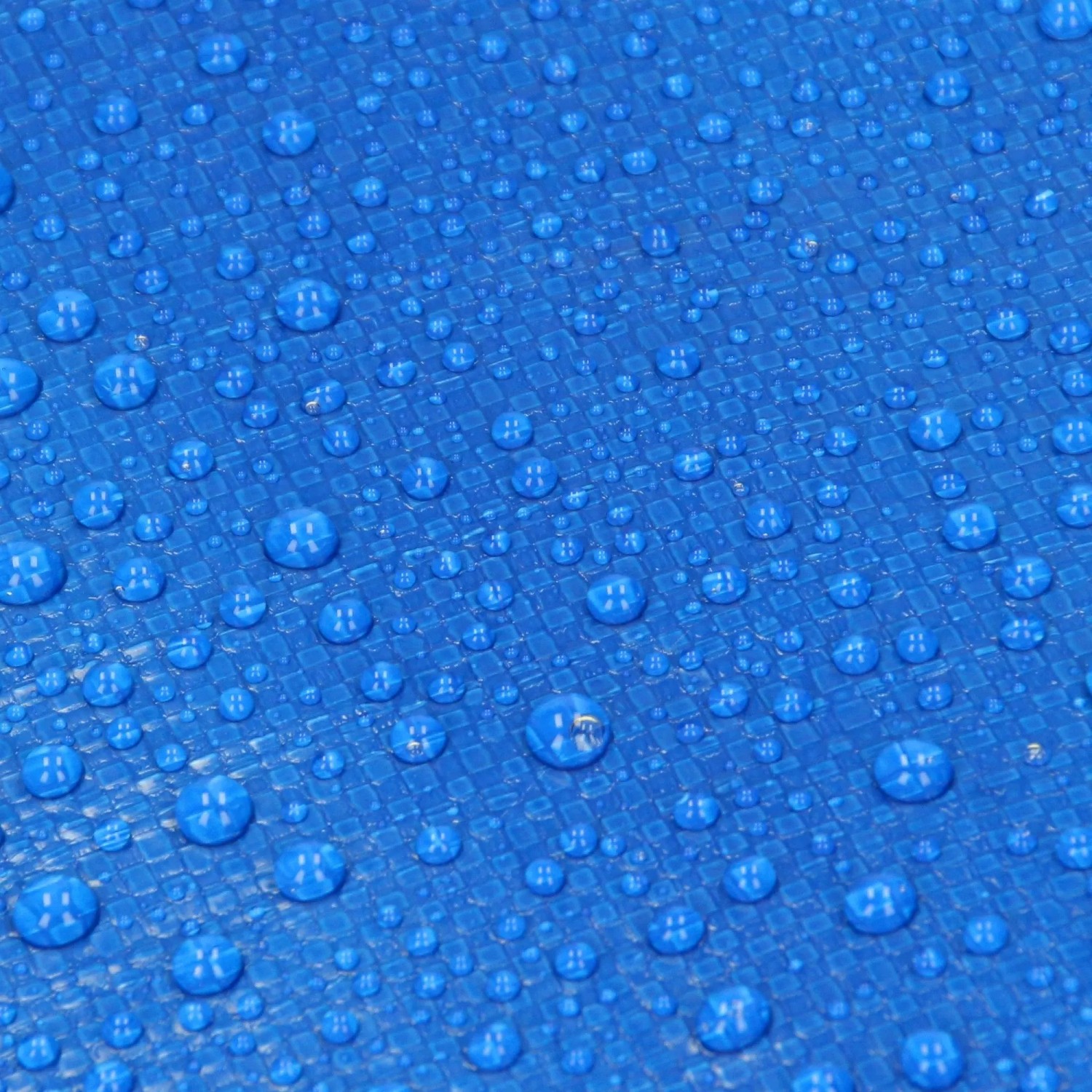 Nahaufnahme einer blauen, wasserdichten PE-Abdeckplane mit Wassertropfen auf der strukturierten Oberfläche.