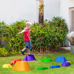 Kind balanciert auf bunten Outsunny Flusssteinen im Garten. Fördert Gleichgewicht und Koordination.