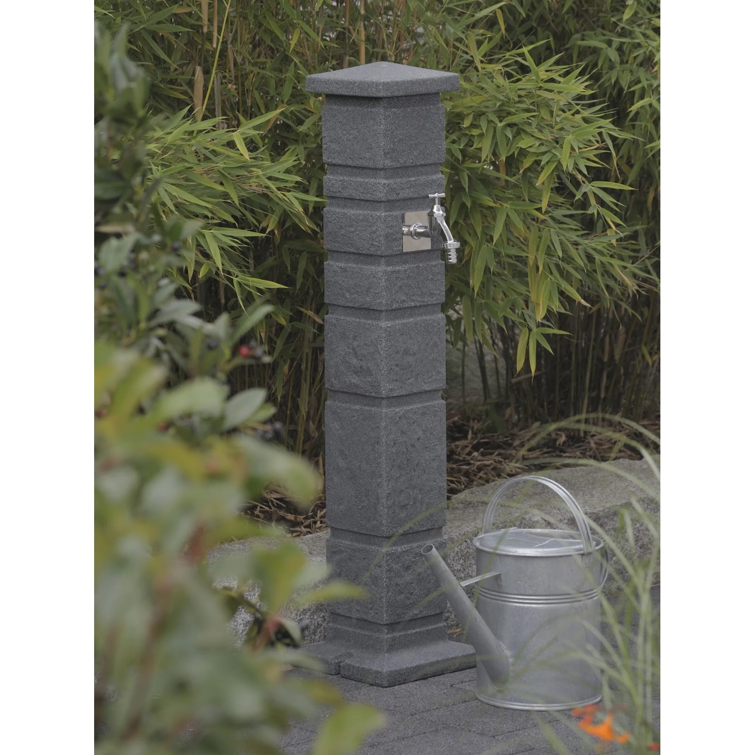 Arves Wasserzapfstelle Romana Black Granit mit Chromhahn im Garten.
