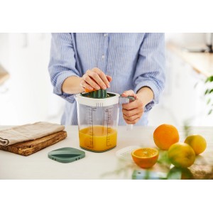 Rotho Messbecher Loft 1,5l: Transparent mit grünem Deckel, mit Zitruspresse in Nutzung.