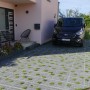 Verlegtes HL Drainpflaster mit Füllsteinen in Steingrau, befahren mit einem PKW.