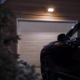 Philips Hue Discover: LED-Wandleuchte Flutlicht am Haus mit Auto vor Garage.
