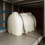 Weißer KMND 2000L Horizontal Trinkwasser Wassertank mit rotem Deckel, sicher verzurrt im Transporter.