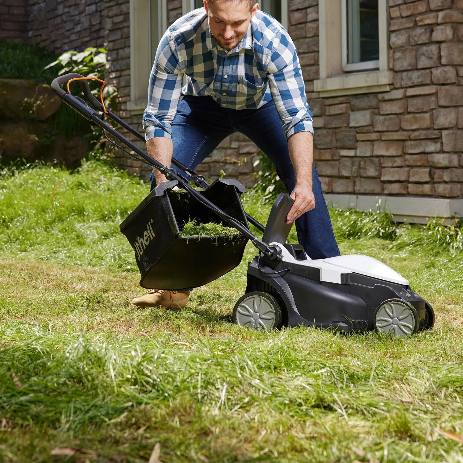 Litheli Akku-Rasenmäher beim Entleeren des Fangkorbs. Kompakter Rasenmäher für den Garten.