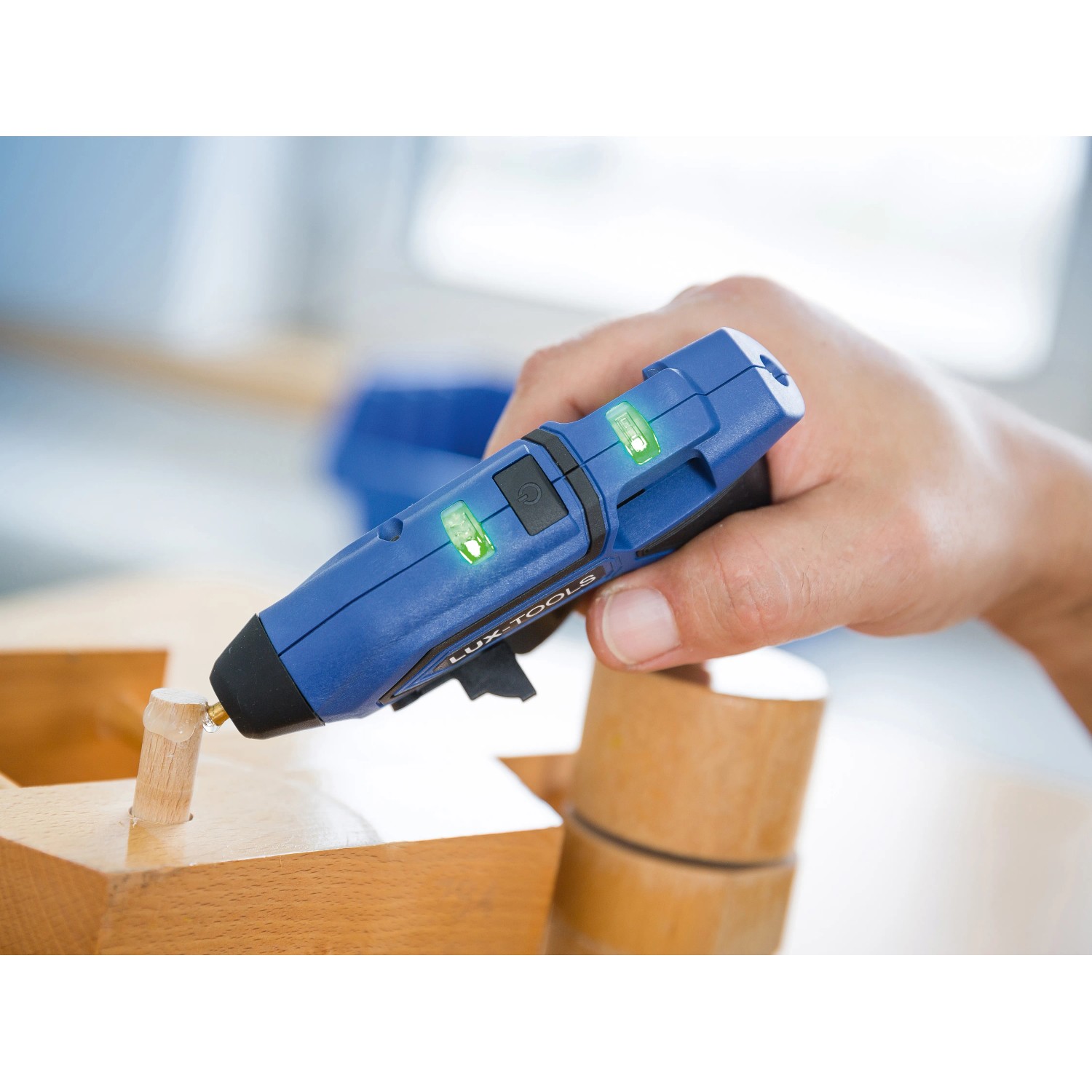 Blaue LUX Akku-Heißklebepistole AHKP-3,6/1,7 beim Verkleben von Holz.