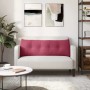 Weinrotes Samt Rückenkissen mit Knopfheftung auf hellem Sofa. Kissen für Wohnzimmer Komfort.