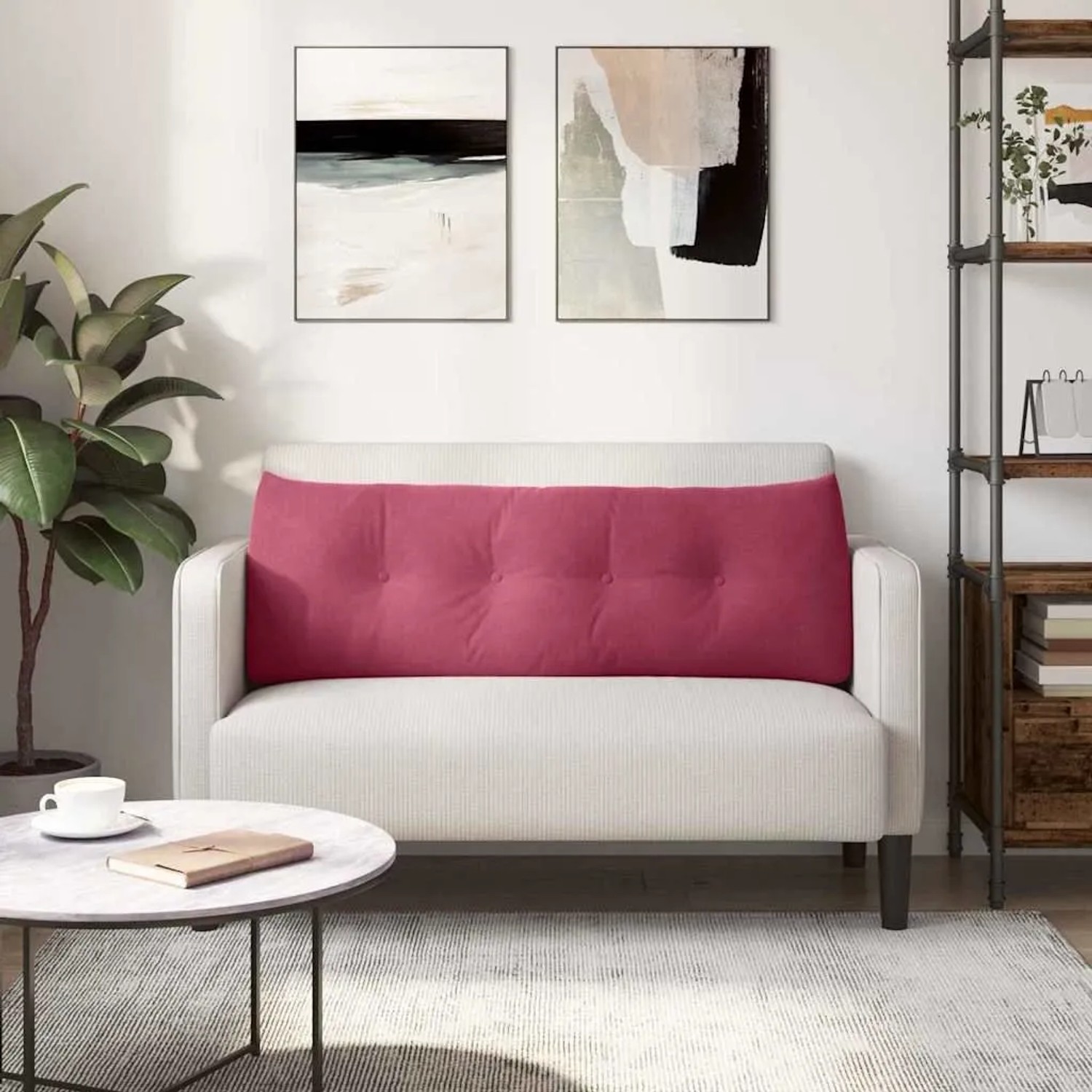 Weinrotes Samt Rückenkissen mit Knopfheftung auf hellem Sofa. Kissen für Wohnzimmer Komfort.