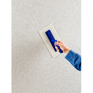 Auftragen von Knauf Diamant Mineralputz (2mm) auf eine Wand mit einer Reibeputzstruktur.