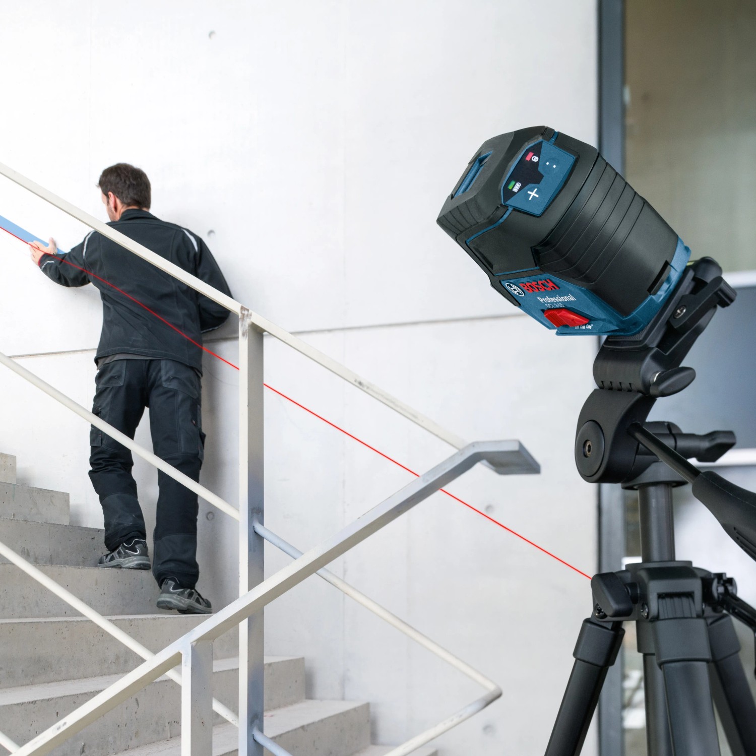 Bosch Professional GCL 2-15 Linienlaser im Einsatz auf Stativ, projiziert Laserlinie an Treppe.