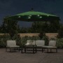 Grüner Ampelschirm mit leuchtenden LEDs auf einer Terrasse bei Nacht, beleuchtet eine Sitzgruppe.