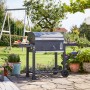 Jamestown Holzkohlegrillwagen Jaxon XL im Garten mit Zubehör auf Seitentischen.