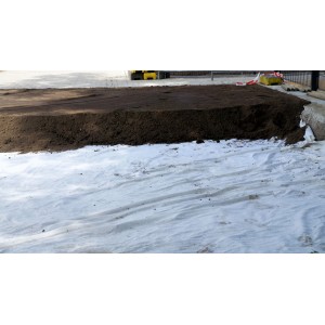 Weißes Aquagart Gartenvlies 150g unter dunkler Erde, als Unkrautschutz oder Drainage im Gartenbau.