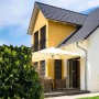 Schwarzer französischer Balkon aus Stahl mit 16 Füllstäben an gelbem Haus. Robuste Fenstersicherung.