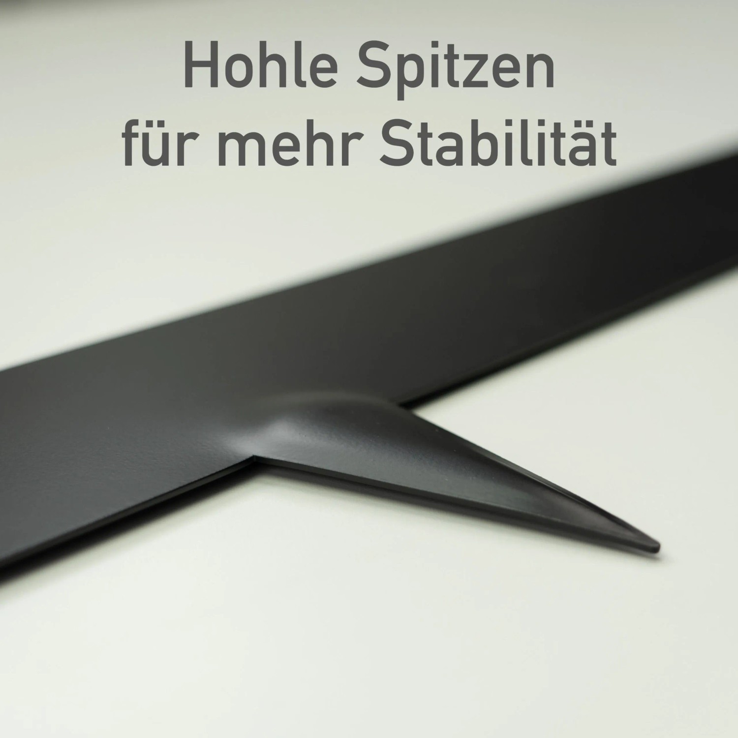 Nahaufnahme der anthrazitfarbenen Metall Rasenkante mit hohler Spitze für Stabilität. Ideal für Beete.