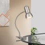 Satinfarbene Klemmleuchte mit flexiblem Schwanenhals, an Tischplatte befestigt. Moderne Innenleuchte für gezieltes Licht.