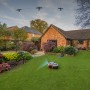 Segway Navimow Mähroboter i105E im Einsatz auf Rasenfläche vor einem Haus. Satellitenverbindung wird angezeigt.