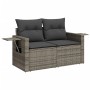 Graue 2-Sitzer Garten-Sofagarnitur aus Polyrattan mit dunklen Kissen und ausklappbaren Ablagen.
