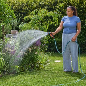 Frau bewässert Garten mit Gardena Multifunktionsbrause Classic. Gartenspritze mit 4 Sprühbildern.