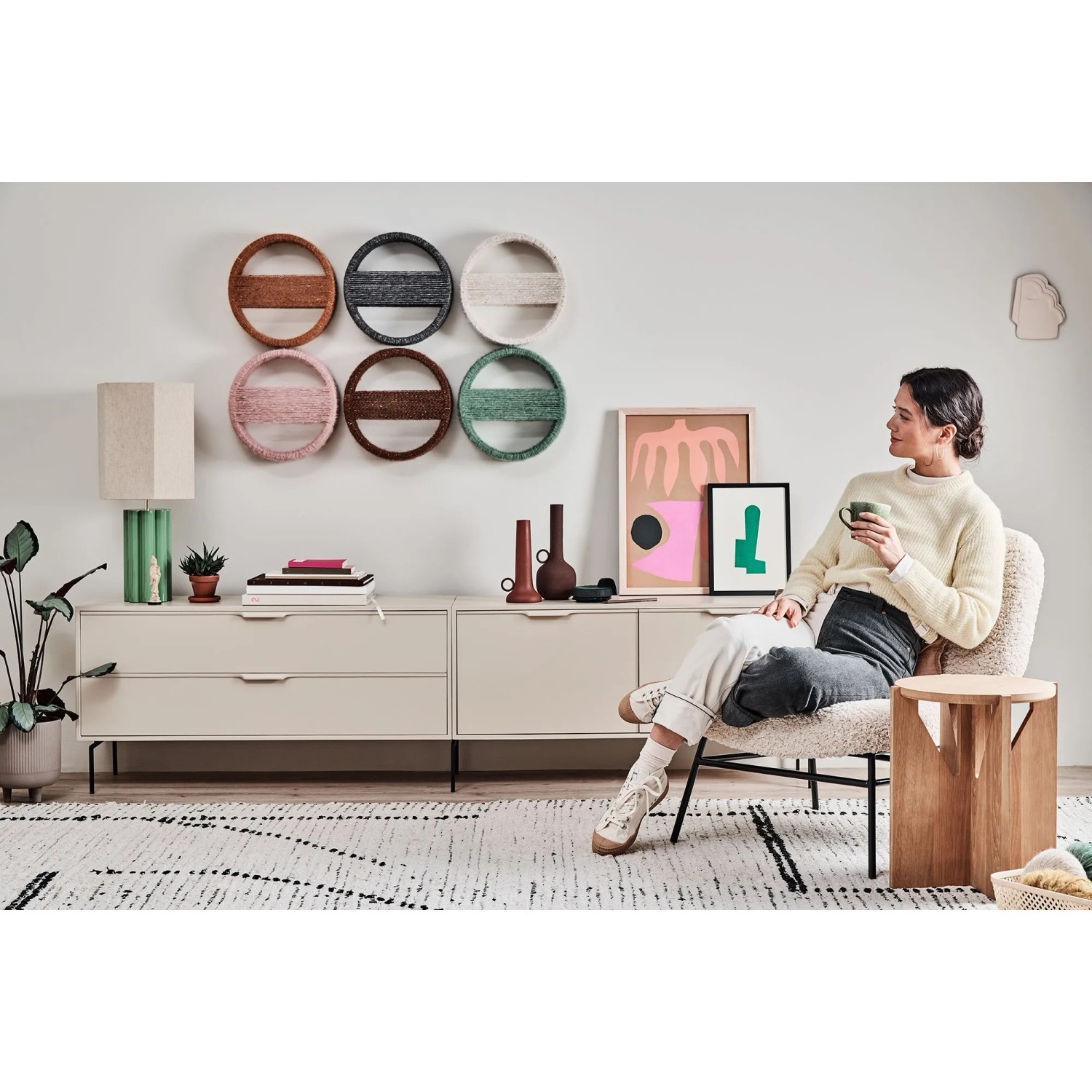 Wohnzimmer mit dekorativen Wandelementen in verschiedenen Farben über einer Kommode.